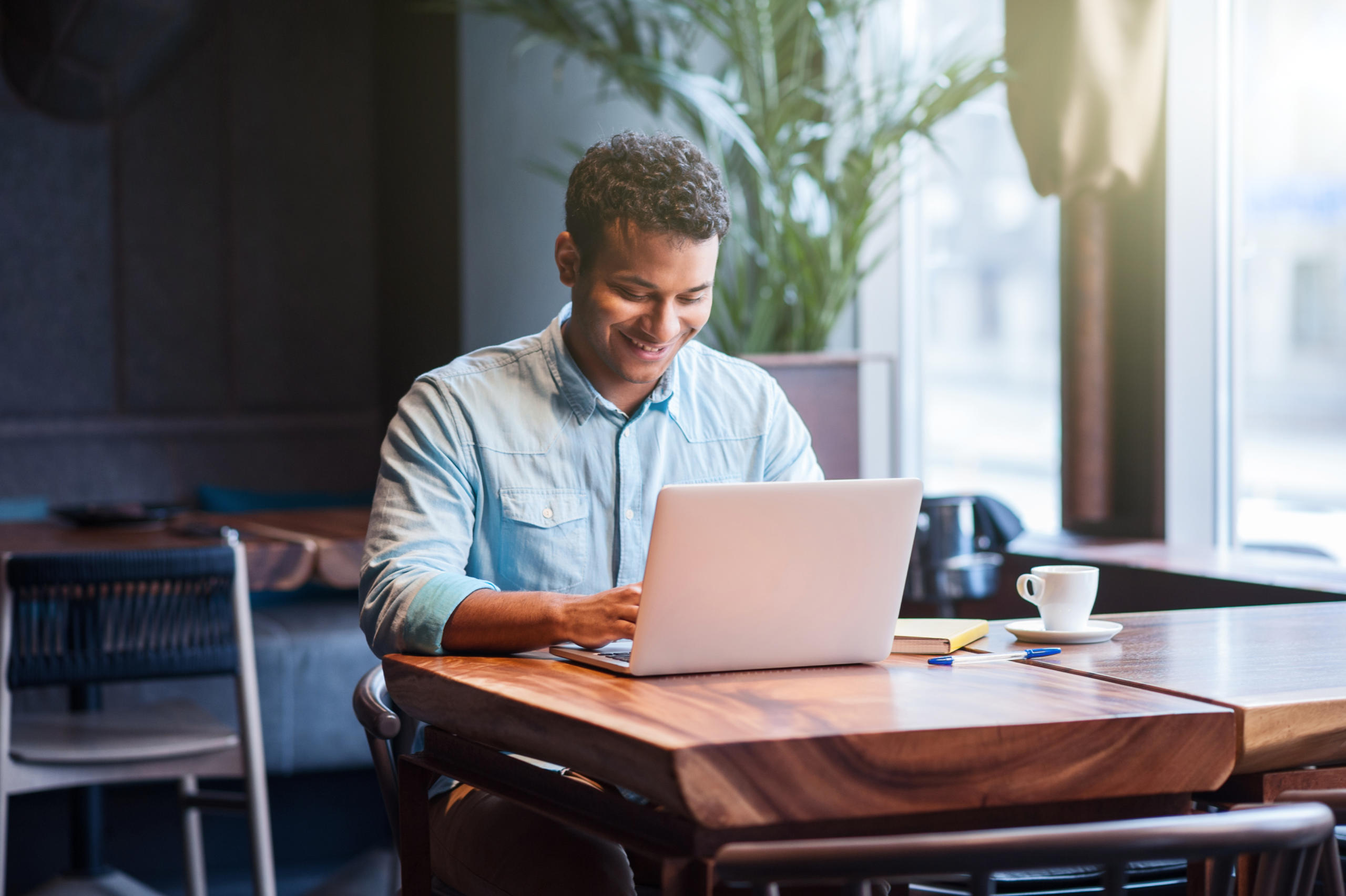 man at a coffee shop alone working on laptop