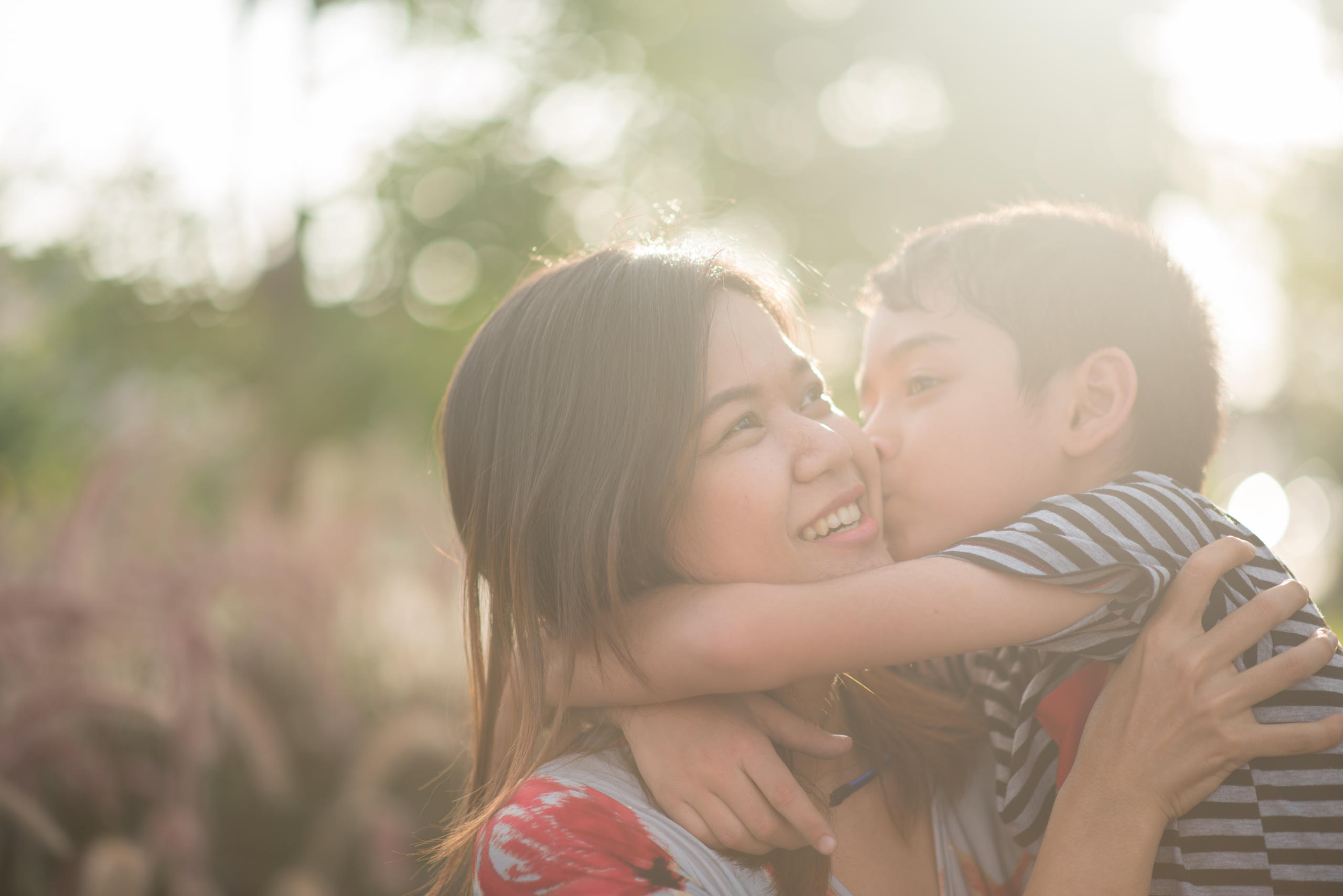 mother holding son getting kiss on the cheek