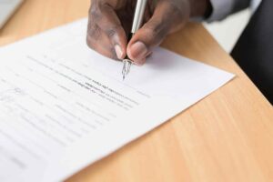 waiver of inadmissibility feature image showing man writing with pen